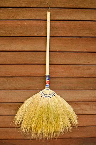 Broom on wooden wall