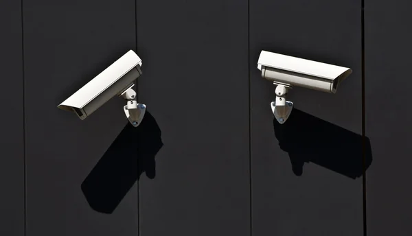Two surveillance cameras on the wall of a public building