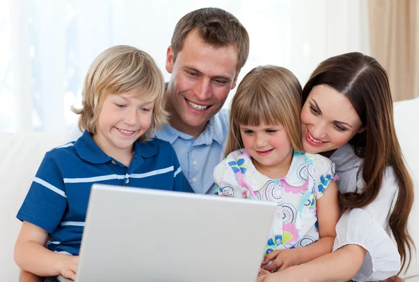 Smiling family using a laptop