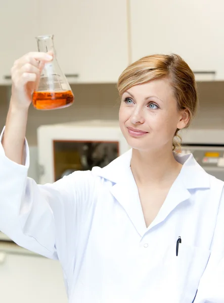 Portrait of a bright female scientist looking at an erlenmeyer