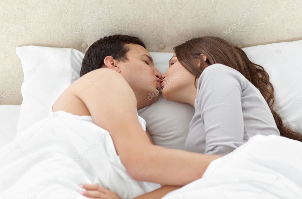 Молодая пара занимается сексом на кровати в спальне