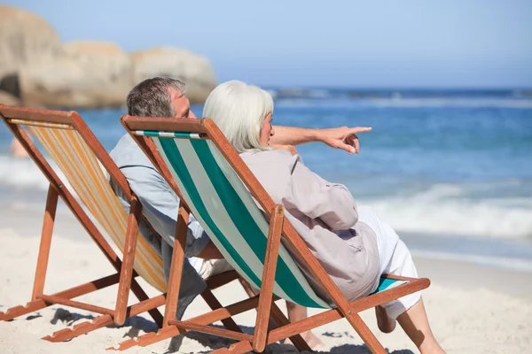 Retired couple sitting on deck chairs