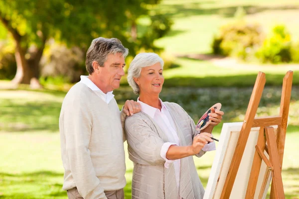 Retired couple painting in the park