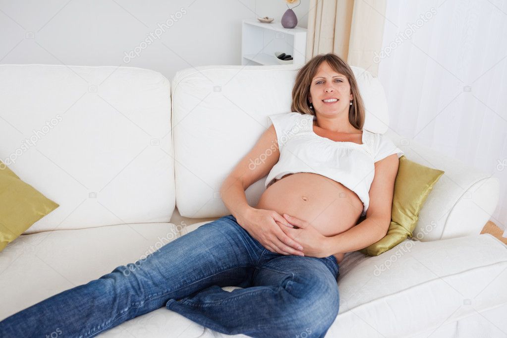 Зрелая беременная жена позирует в кресле