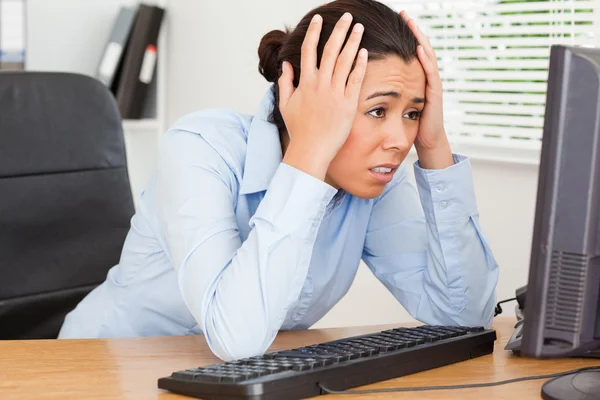Good looking upset woman looking at a computer screen while sitt