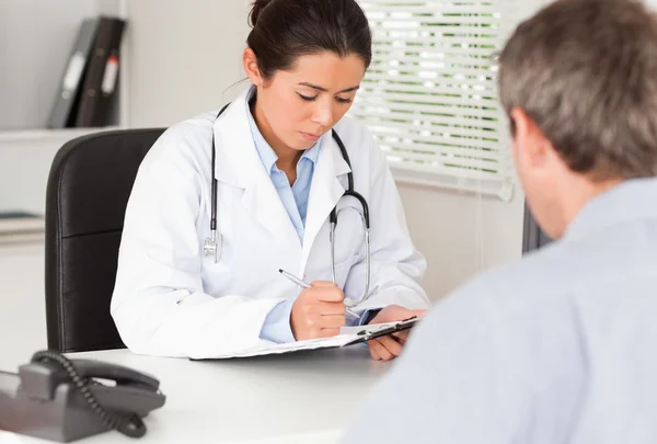 Pretty female doctor consulting the patient\'s medical analysis