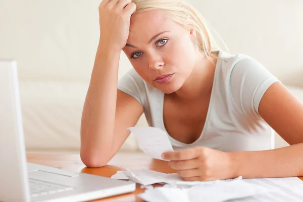 Worried woman doing accounts looking into the camera