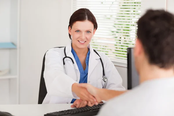 Female doctor hand shaking with patient