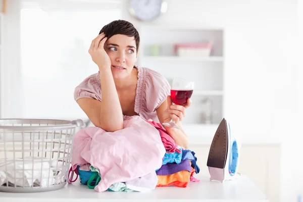 Upset woman with wine and a pile of clothes