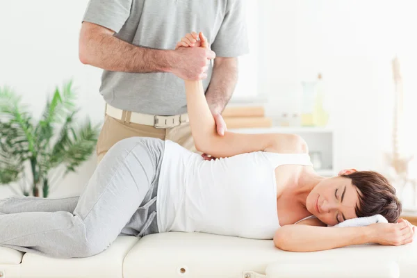 Chiropractor stretches a woman\'s arm