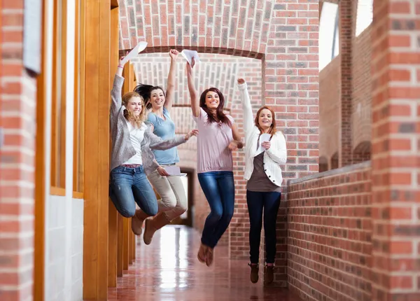 Students jumping with their results