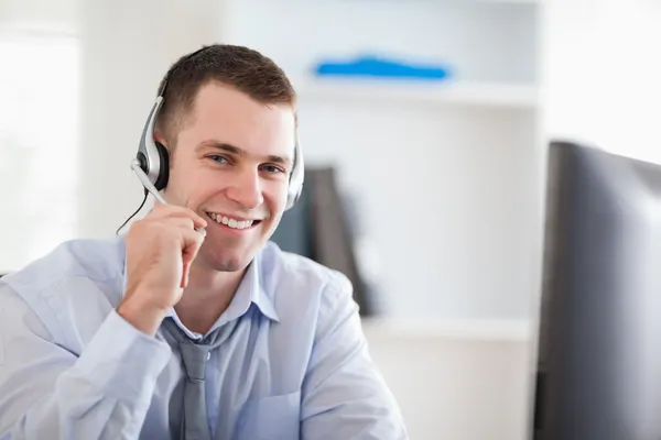 Smiling call center agent speaking with costumer