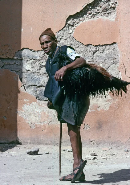 MARRAKECH, MOROCCO – AUGUST, 1979: A water seller carries a bo