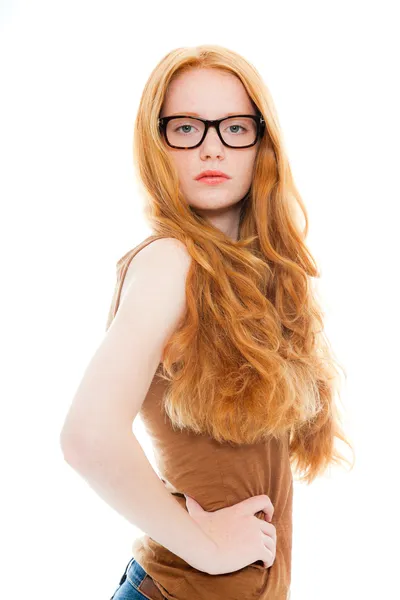 Pretty girl with long red hair wearing brown shirt and vintage glasses. Fashion studio shot isolated on white background.