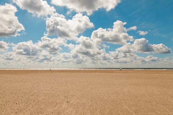 Coastal landscape with blue cloudy sky on summers day. Dutch north sea. IJmuiden. The Netherlands. Seascape.