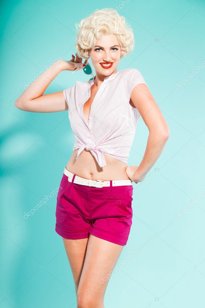 Sexy Blonde Pin Up Girl Wearing Pink Shirt And Hot Pants Holding