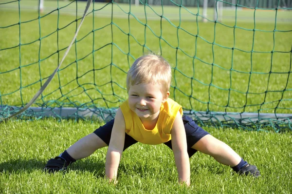Young boy or kid plays soccer or football sports for exercise an