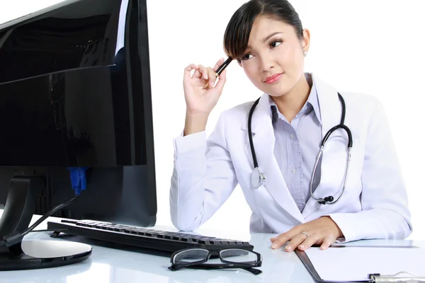 Woman doctor at computer thinking