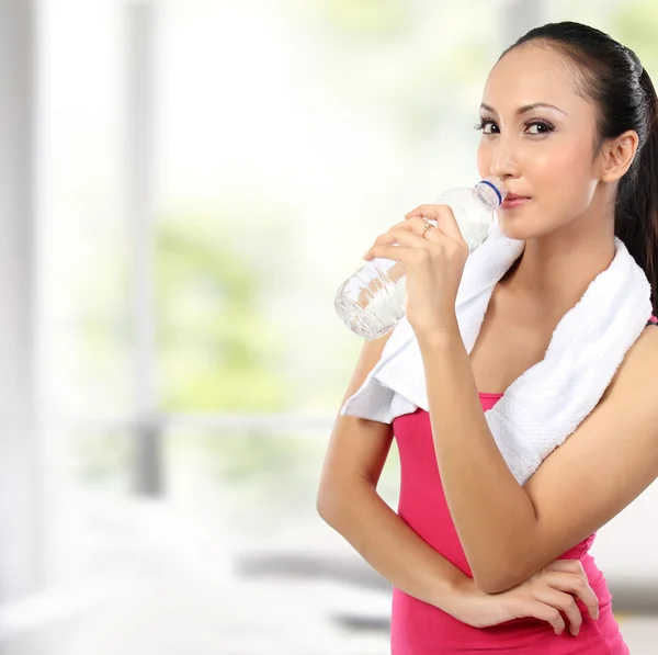 Attractive asian smiling woman drinking water