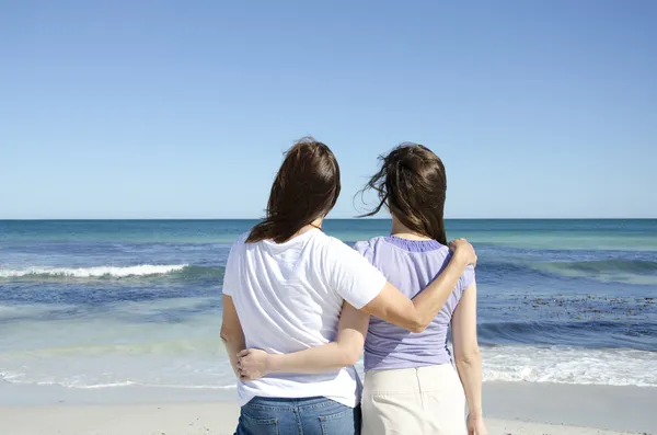 Lesbian couple holding each other at beach