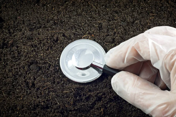 Black soil and stethoscope concept of world without pollution