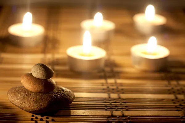 Spa stones and candles in night background