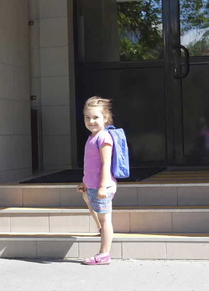 First day of school and happy young girl with backpack
