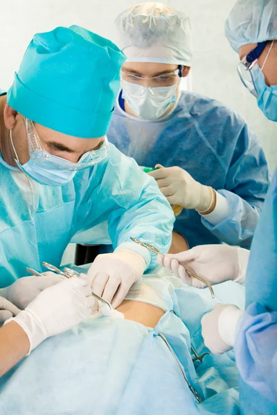 Medical professionals performing an operation on woman