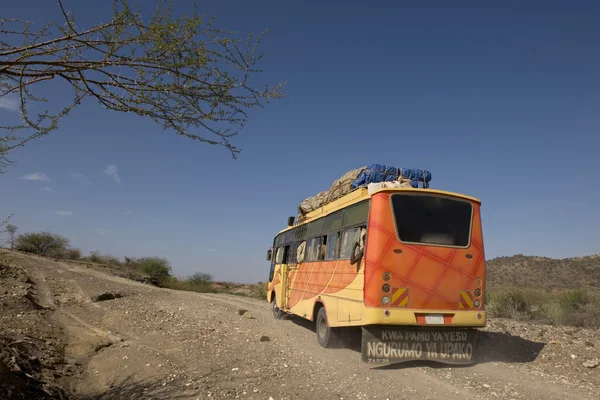 Rear view of bus traveling on dirt road, Tanzania, Africa