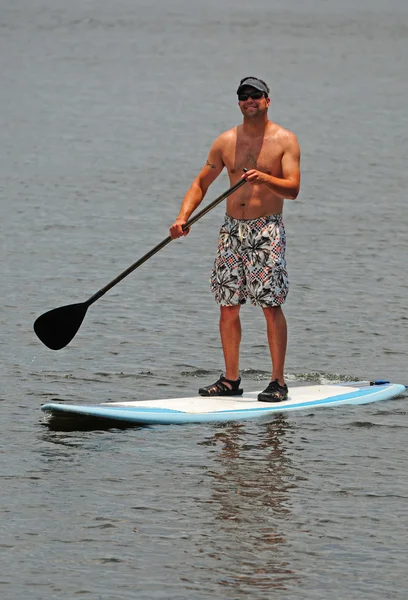 Man getting exercise by paddleboarding