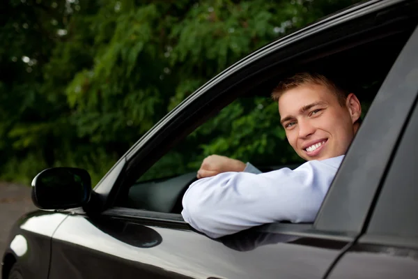 Young man in the car smiling