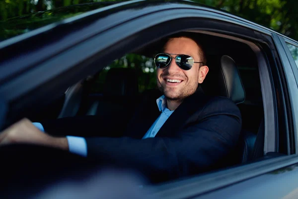 Businessman in car smiling