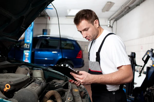 Auto mechanic checking car in service
