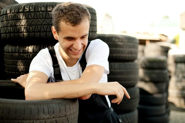 Young mechanic laughing outside car service