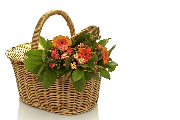 A bouquet of flowers in a wicker basket