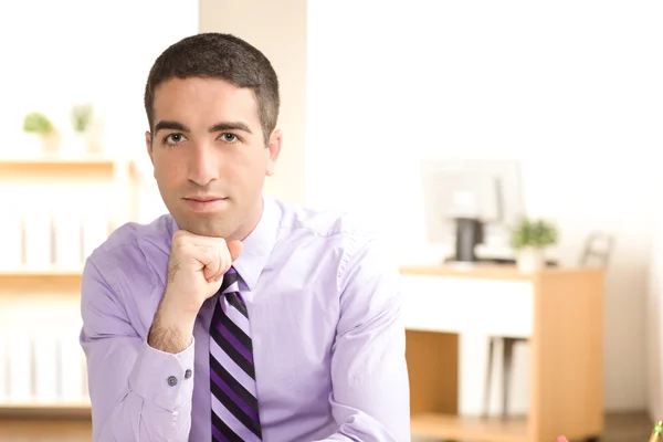 Attractive young executive with chin on hand