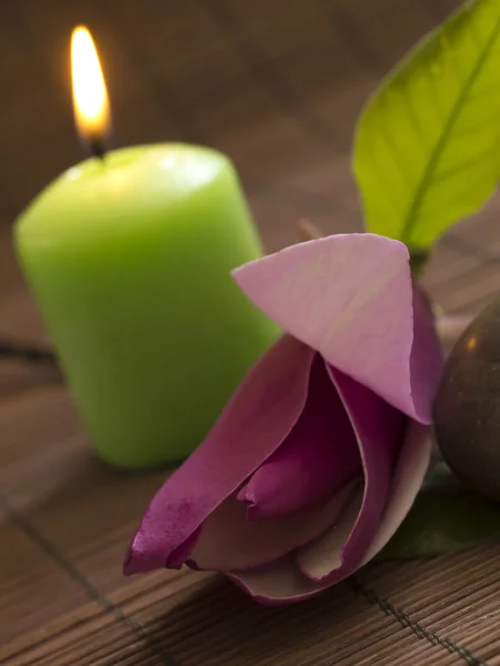 Stone with water drop and burning candle, spa concept