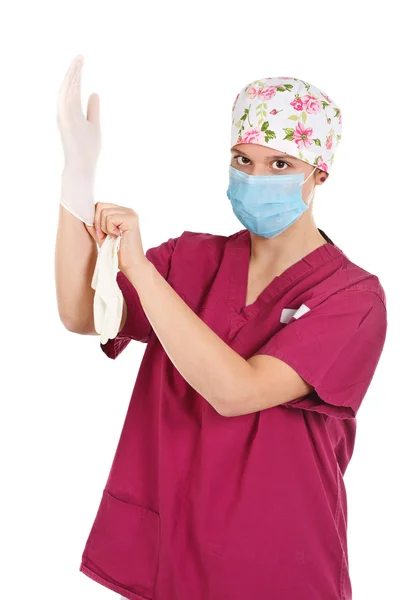 Young female doctor putting on glove