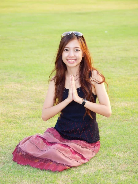 A portrait of attractive asian woman greeting on green grass fie