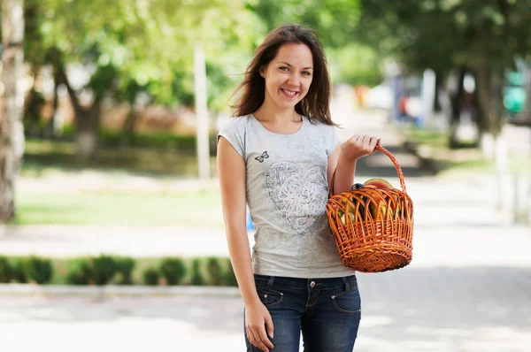 The girl is staying in the street with basket