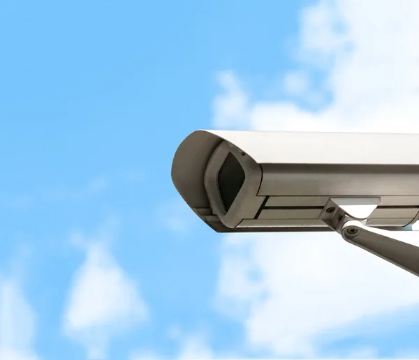 Security camera with cloudy sky in background