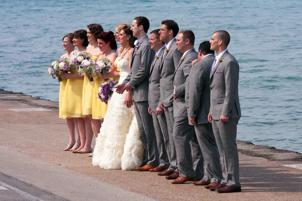 Wedding Party Takes Picture At Edge Of Lake Michigan