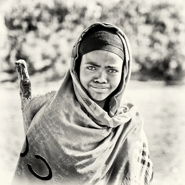 An Ethiopian woman watches straight and smiles to the camera