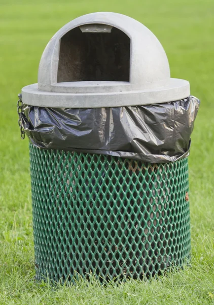 A green and gray park garbage can.