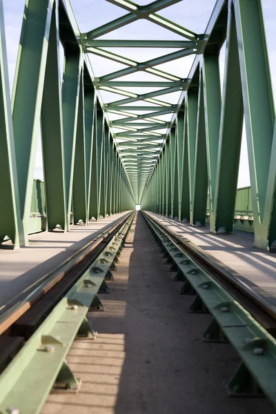 Train bridge with green painted steel pillars and tracks.