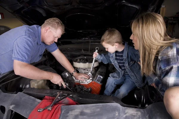 Family working on car