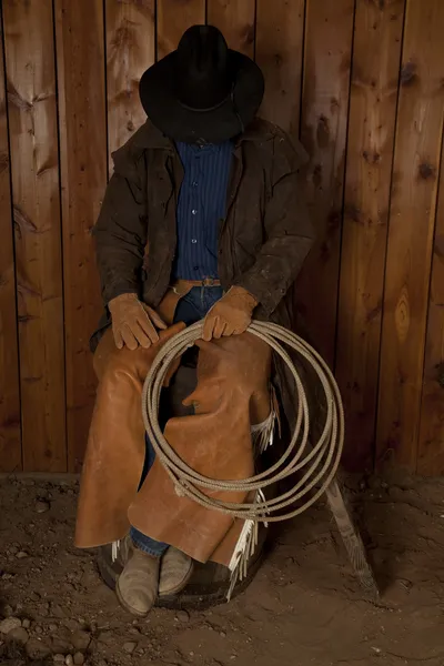Cowboy sitting on barrel head down