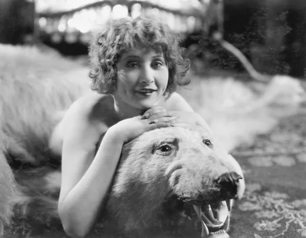 Portrait of woman lying on bear rug