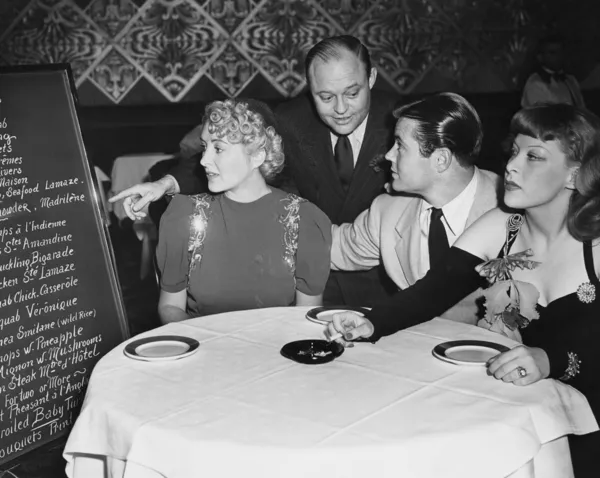 Waiter and customers in restaurant