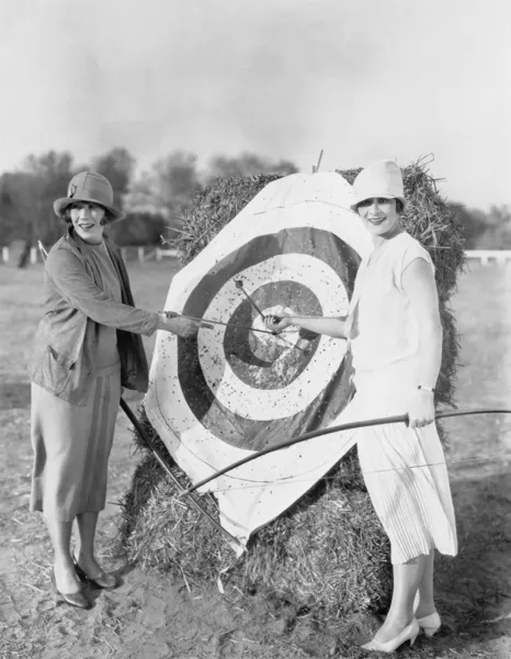Women with bulls eye in archery target